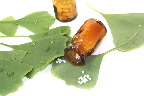 Ginkgo leaves with globules and pharmacist bottles — Stock Photo, Image