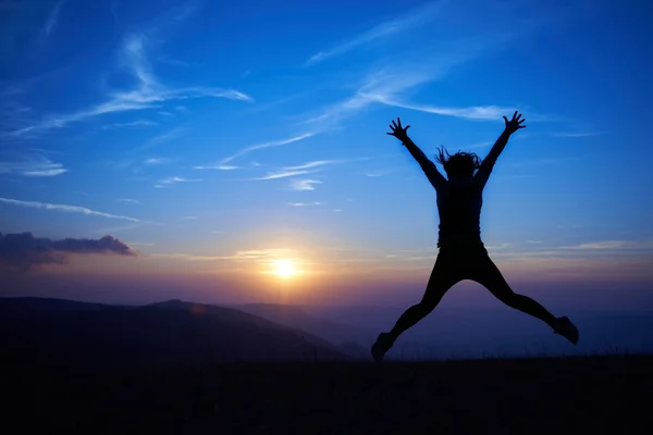 Silhouet van een jonge vrouw springen — Stockfoto