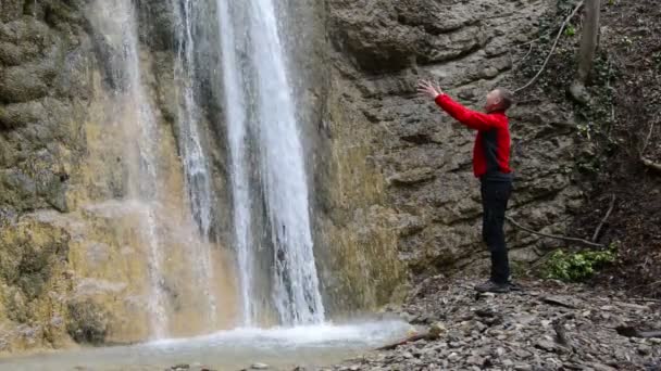 Man in de omgeving van waterval afwas in de ochtend. — Stockvideo