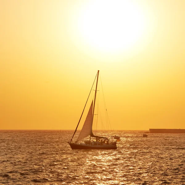 Velero contra puesta de sol en el mar —  Fotos de Stock