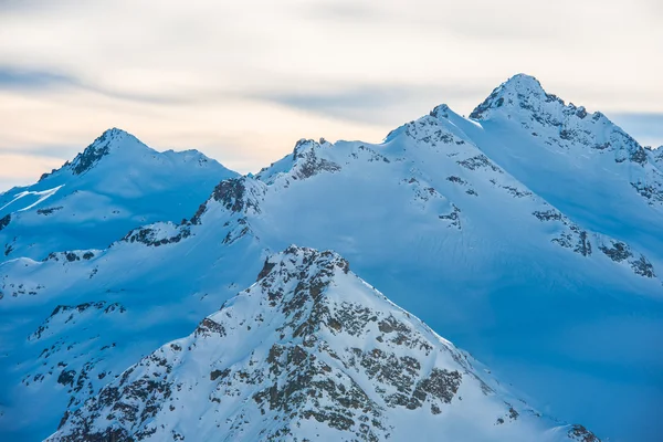 Montañas azules nevadas en las nubes —  Fotos de Stock