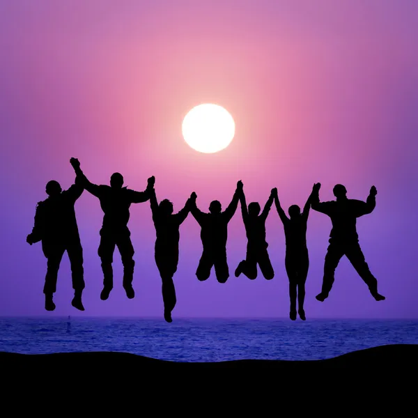 Group of friends jumping against sunset — Stock Photo, Image