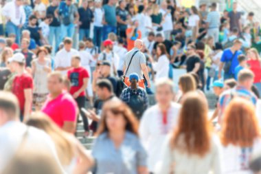 Yoğun şehir caddesinde kadın ve erkeklerin olduğu bir kalabalık.