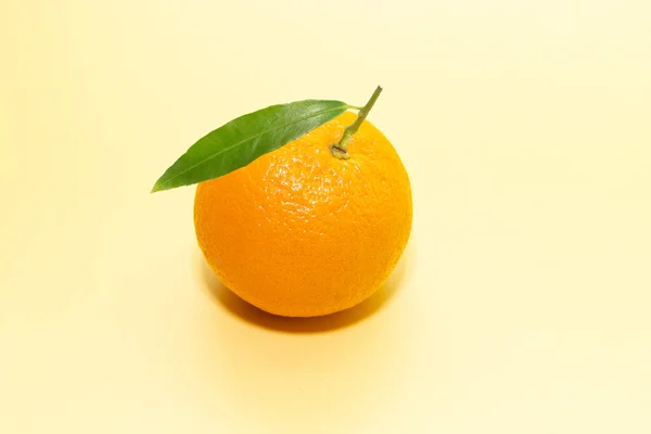 Pomarańczowy Cytrusowy Zielonym Liściem Żółtym Tle — Zdjęcie stockowe