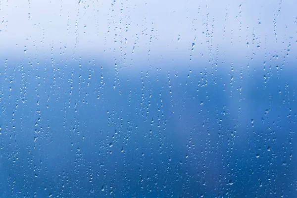 雨の水は青い窓ガラス表面にパターンをドロップ — ストック写真