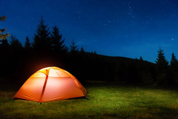 夜空と星の暗い夜の森の中のオレンジの照明テント — ストック写真
