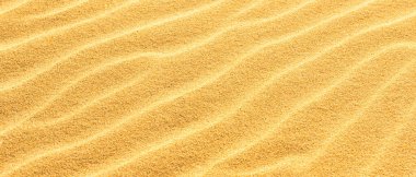 Sarı kumlu çöl arka planında kum panoramik dokusu.