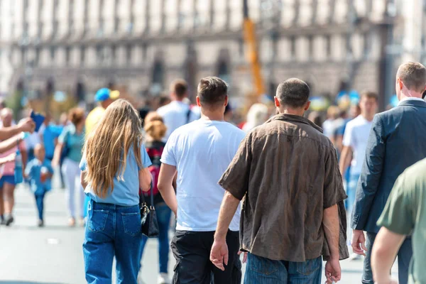 Yoğun şehir caddesinde kadın ve erkeklerin olduğu bir kalabalık.