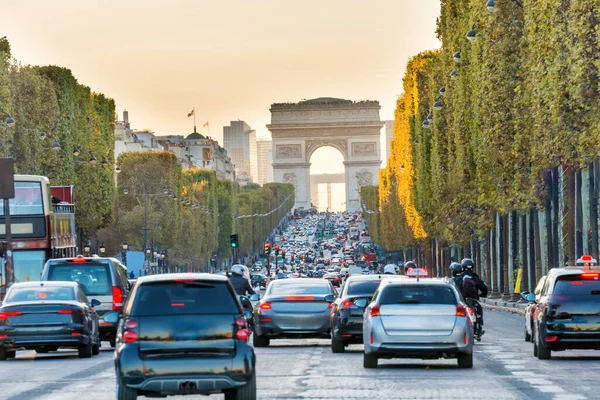 Champs-Elysees Bulvarı 'nda gün batımı araba trafiği ve Zafer Takı manzaralı. Paris, Fransa