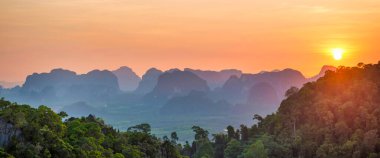 Mountains sunset panorama landscape with dramatic sunset mountain, tropical forest and mountain ridge on horizon. Krabi, Thailand
