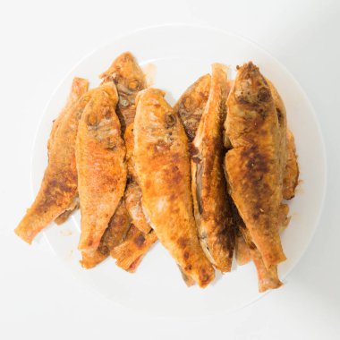 Tabak kızarmış balıkların beyaz zemin üzerine kırmızı kefal izole