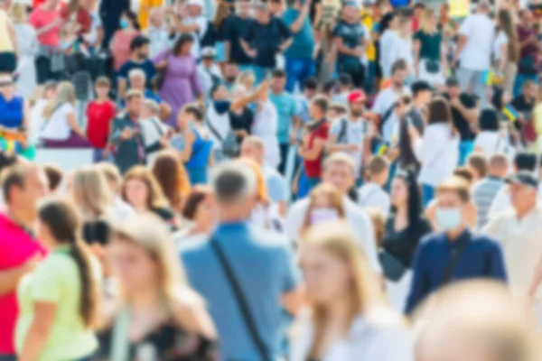 Crowd of people with blurred men and women on busy city street