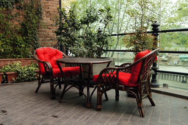 Красные стулья на открытом воздухе со столом — стоковое фото
