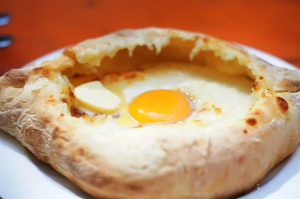 Ajarian or Adjaruli khachapuri, filled with cheese and topped wi — Stock Photo, Image