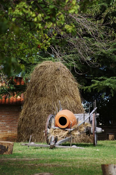 Paisagem rural: jarro de vinho tradicional georgiano e feno — Fotografia de Stock