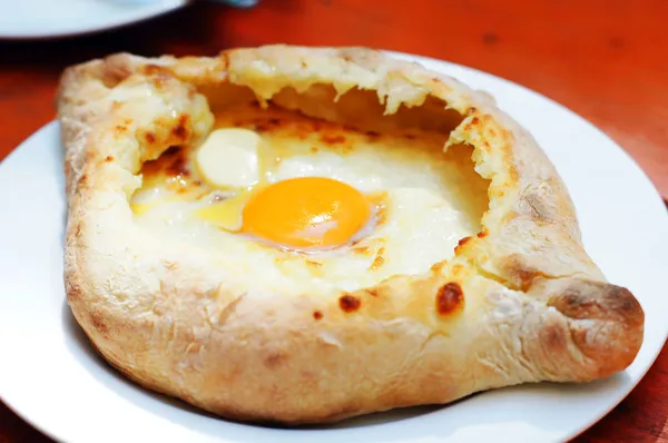 Ajarian ou Adjaruli khachapuri, cheio de queijo e com cobertura wi — Fotografia de Stock