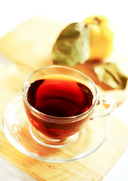 Tasse Tee und Quittenfrüchte auf dem Holztisch — Stockfoto