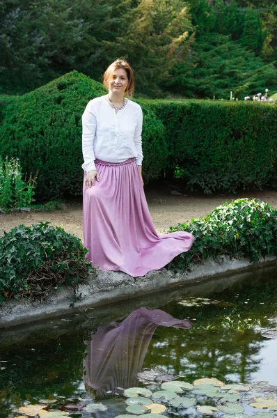 Frau am Teich mit Lilien — Stockfoto