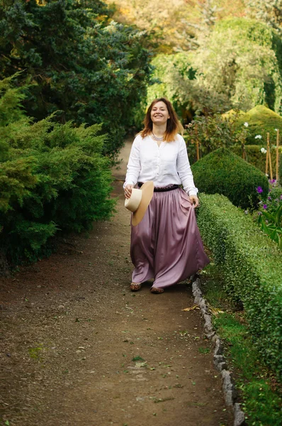 Junge Frau geht im Park spazieren — Stockfoto