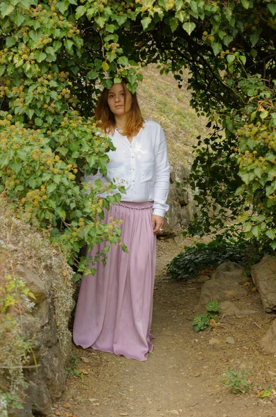 Junge Frau geht im Park spazieren — Stockfoto