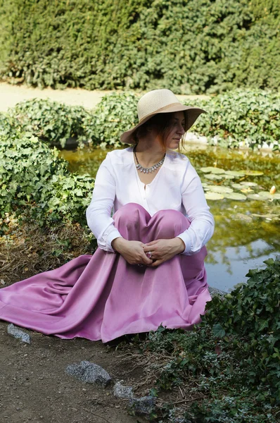 Vrouw op een vijver met lelies — Stockfoto