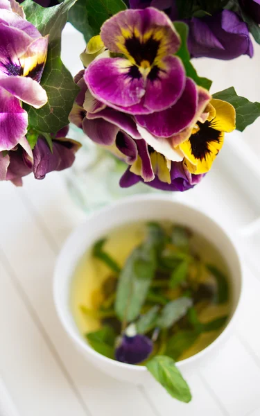 Chá de menta, flores de violas e bom dia. — Fotografia de Stock