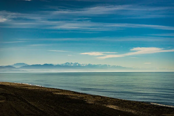 Czarna Piaszczysta Plaża Wulkaniczna Góry Kaukazu Szczytami Śniegu Okresie Zimowym — Zdjęcie stockowe
