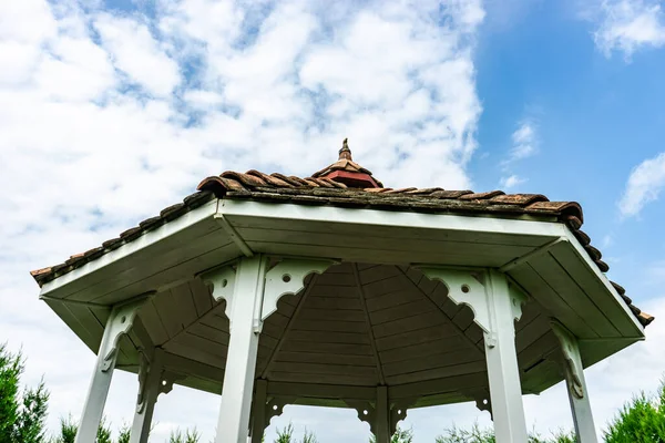 Old styled wooden pavilion with tiled roof in the garden