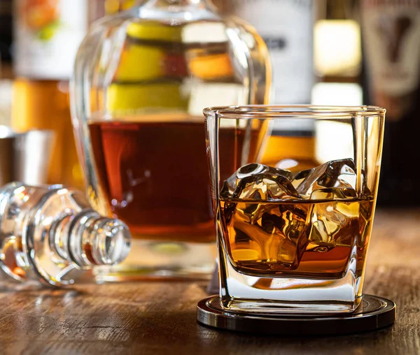 Vaso Whisky Las Rocas Una Barra Madera Con Botellas Fondo — Foto de Stock