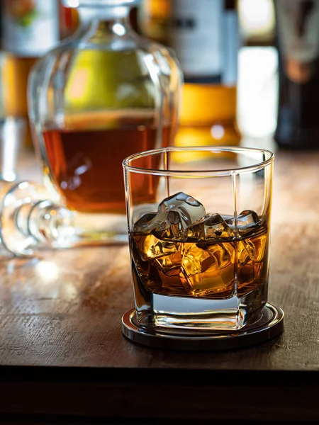 Glas Whisky Met Ijs Een Houten Barblad Met Flessen Achtergrond — Stockfoto