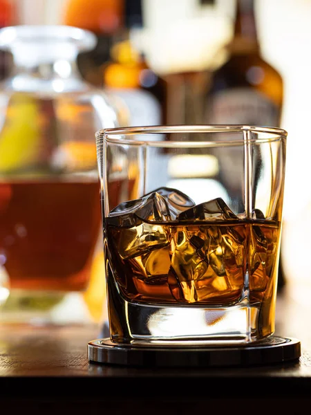 Glas Whisky Klipporna Trä Bar Topp Med Flaskor Bakgrunden — Stockfoto