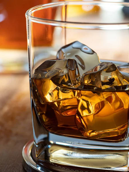 Bicchiere Whisky Sulle Rocce Piano Legno Con Bottiglie Sullo Sfondo — Foto Stock