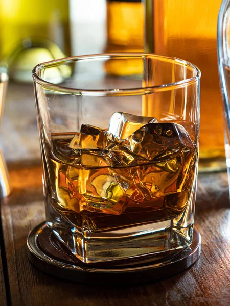 Glas Whisky Met Ijs Een Houten Barblad Met Flessen Achtergrond — Stockfoto