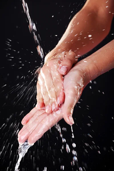 Agua cayendo sobre las manos femeninas — Foto de Stock