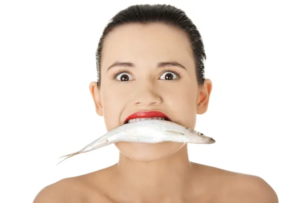 Bella giovane donna con il pesce in bocca — Foto Stock