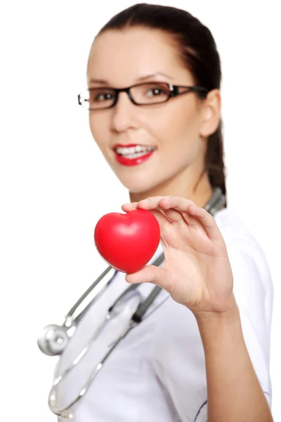 Female doctor holding red heart in hand — Stock Photo, Image