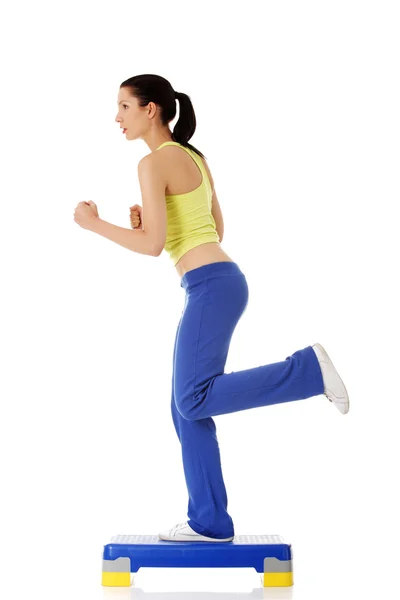 Chica fitness está haciendo ejercicio con stepper — Foto de Stock