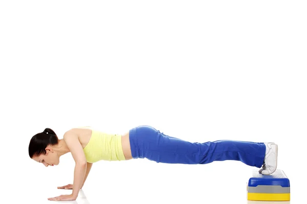 Fitness girl is working out with stepper — Stock Photo, Image