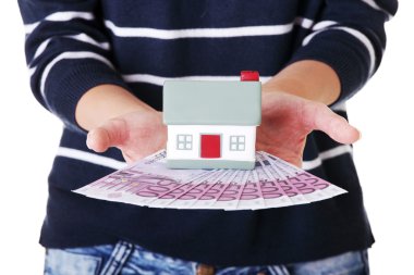 Euro Bono ve ev modeli üzerinde beyaz tutan kadın.