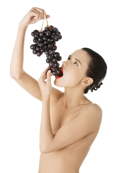 Beautiful sensual brunette eating grapes — Stock Photo, Image