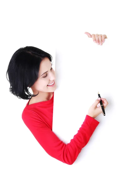 Feliz hermosa mujer escribiendo con una pluma en el tablero en blanco . —  Fotos de Stock