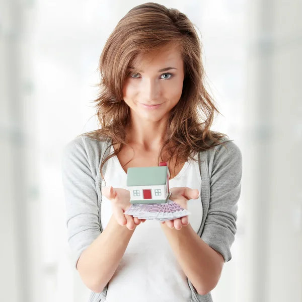 Woman holding euros bills and house model — Stock Photo, Image