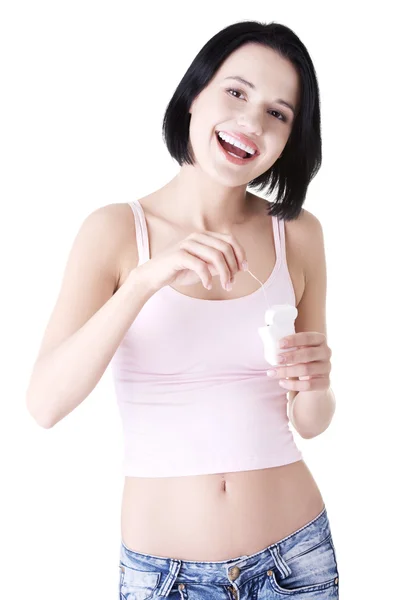 Mujer joven usando hilo dental — Foto de Stock