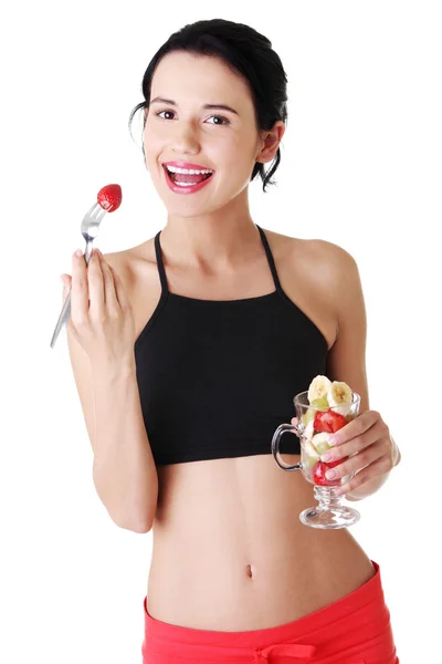 Pretty fit girl eating fruit salad — Stock Photo, Image