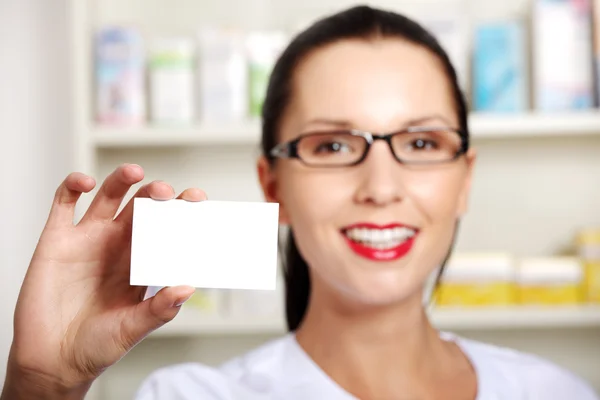 Farmacista femminile con biglietto da visita in farmacia — Foto Stock