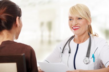 Olgun kadın doktor hasta ile konuşmak.