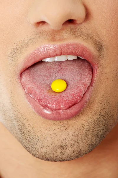 Young man taking a pill — Stock Photo, Image