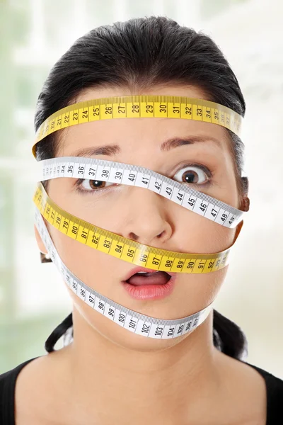 Mujer con cinta métrica alrededor de la cabeza — Foto de Stock