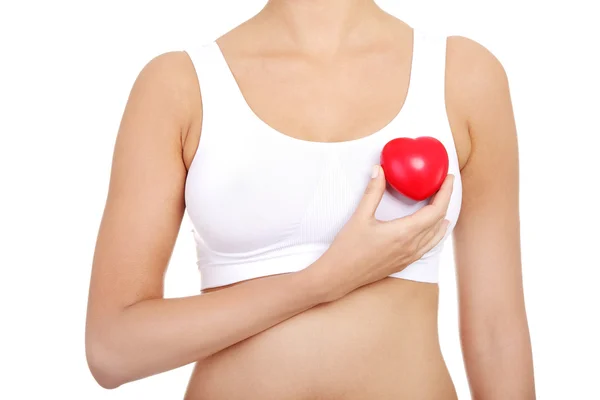Fit female torso with red heart shaped toy — Stock Photo, Image