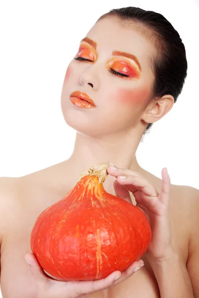 Woman with orange make up holding pumpkin — Stock Photo, Image